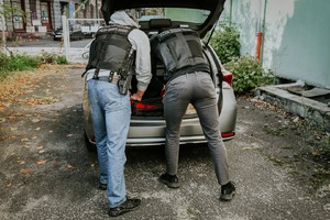 Dwóch funkcjonariuszy Straży Granicznej. Zaglądają do bagażnika