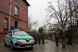 Samochód służbowy SG obok funkcjonariusze SG 