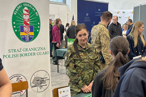 Funkcjonariusze podczas targów. Z lewej strony rollup Straży Granicznej. Funkcjonariusze podczas targów. Z lewej strony rollup Straży Granicznej.