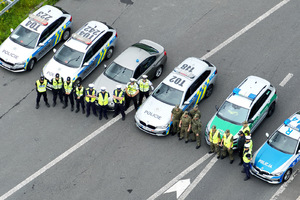  Ujęcie z drona. Radiowozy Policji i Straży Granicznej. Przy samochodach stoją funkcjonariusze