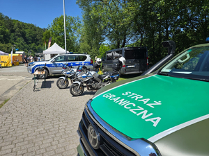  Samochód Straży Granicznej za nim dwa motocykle i samochód Policji.