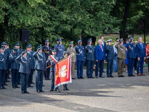  Sztandar z napisem: W służbie ojczyźnie i obywatelom. Funkcjonariusze oddają honory.