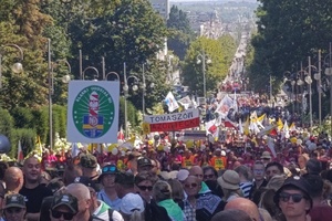  Pielgrzymi idący na Jasną Górę. Trzymają flagi, transparent z napisami Straż Graniczna, Tomaszów Mazowiecki.