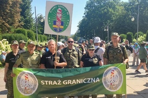  Funkcjonariusze ŚLOSG trzymają baner z napisem Straż Graniczna.