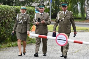  Osoby przechodzące obok szlabanu