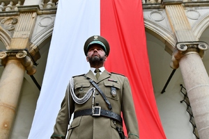  Dowódca uroczystości, za nim flaga RP.