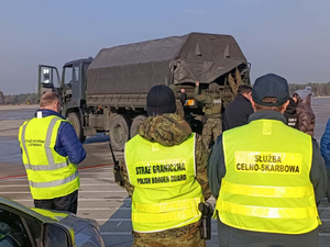 Funkcjonariusze w żółtych kamizelkach, samochód