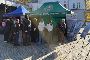  Namiot Straży Granicznej. Plakaty na sztalugach. Osoby przyglądające się.